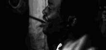 a black and white photo of a man with a spoon in his mouth .