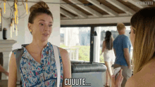 a woman in a floral shirt is talking to another woman and says cuuute .