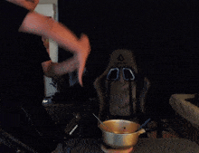 a man stands in front of a shure microphone and a pot with a spoon in it