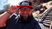 a man wearing a mickey hat and glasses smiles for the camera