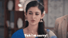 a woman in a blue top is saying that she is sorry .