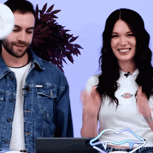 a man in a denim jacket and a woman wearing a white shirt with the word dickies on it