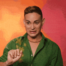a man in a green shirt is making a funny face with his hand