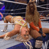 two women wrestling in a ring with a sign that says raw