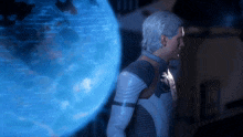 a man with gray hair stands in front of a blue screen