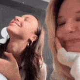 two women are laughing and making funny faces .