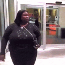 a woman with very large breasts is walking in front of a glass door