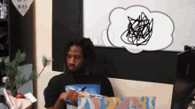a man sitting in front of a computer with a sign that says nan