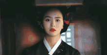 a close up of a woman wearing a traditional korean dress and a hat .