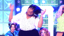 a woman in a white polka dot shirt is dancing