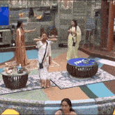 a group of women are standing in a room with a sign that says ' sanjo ' on the bottom right