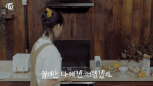 a woman is cooking in a kitchen with a twice logo on the wall