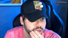 a man with a beard is wearing a black hat with a shark on it