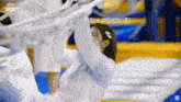 a girl in a white sweater is hanging from a rope in a room with korean writing on it