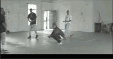 a group of men are squatting on the floor in a room with a sign on the wall that says ' a ' on it