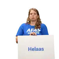 a woman in a blue shirt is holding a cardboard box with the word pindakaas on it