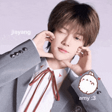 a young man in a suit has jiayang written on the corner of his jacket