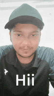 a man wearing a hat and a black shirt with the word hii written on it .