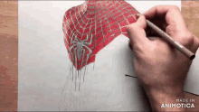 a person is drawing a spider man costume on a piece of paper with a marker