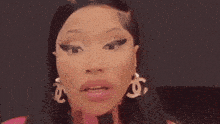a close up of a woman 's face with her mouth open wearing earrings .