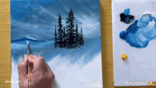 a person is painting a picture of trees on a canvas which is made in the animatica app