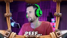 a man wearing green headphones is sitting in front of a microphone and says pfff ...