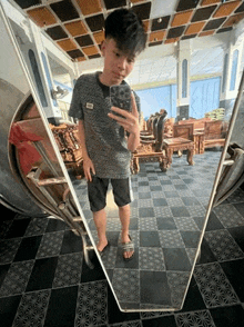 a young boy is taking a selfie in front of a mirror