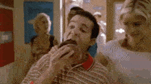 a man is eating a donut in a hallway .