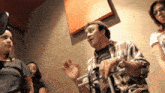 a man in a plaid shirt is talking to a group of people