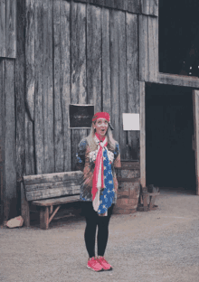 a woman stands in front of a barn wearing a shirt that says peace