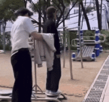 a man standing next to another man in a park