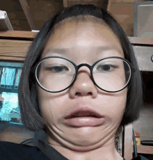 a woman wearing glasses is making a funny face with her mouth open