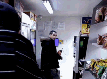 a man is standing in a store holding a bottle of coca cola
