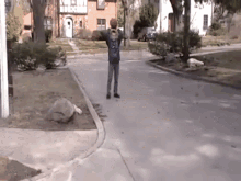 a person holding a basketball on a sidewalk in front of a house