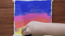 a person is painting a sunset with a brush