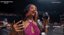 a woman in a pink dress holds a glass of wine and takes a selfie