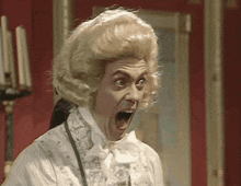 a man wearing a wig and a white shirt has his mouth open