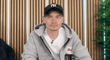 a man wearing a ny hat is holding a can of monster energy
