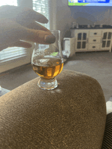 a person is holding a glass of alcohol that says johnny james on it
