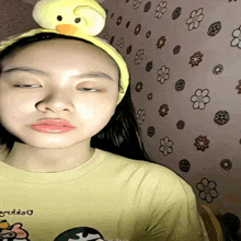 a girl wearing a headband with a yellow duck on top of her head