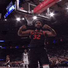 a basketball player with the number 32 on his jersey flexes his muscles