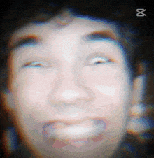 a close up of a person 's face with a x on the bottom right