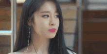 a close up of a woman 's face with long black hair and pink lips .