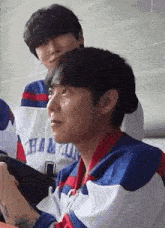 a group of young men are sitting next to each other in a room .