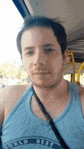 a man wearing a blue tank top with the word world best on it