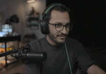 a man wearing headphones and glasses is sitting in front of a mic