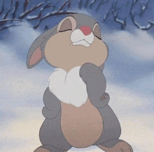 a cartoon rabbit is standing in the snow with its eyes closed and a sad look on its face .