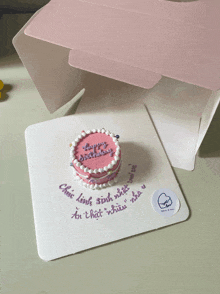 a small pink cake with the words happy birthday on it