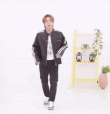 a man in a black jacket and black pants is dancing .