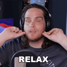 a man wearing headphones is making a funny face and the word relax is on the front of his shirt